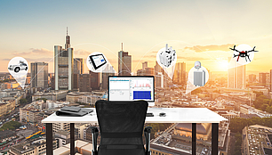 Office desk overlooking a city skyline with icons representing LS OBSERVER spectrum monitoring and RF data collection