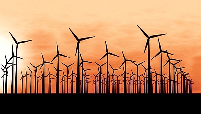 Wind turbines at sunrise representing reliable communication networks for utilities and energy providers.